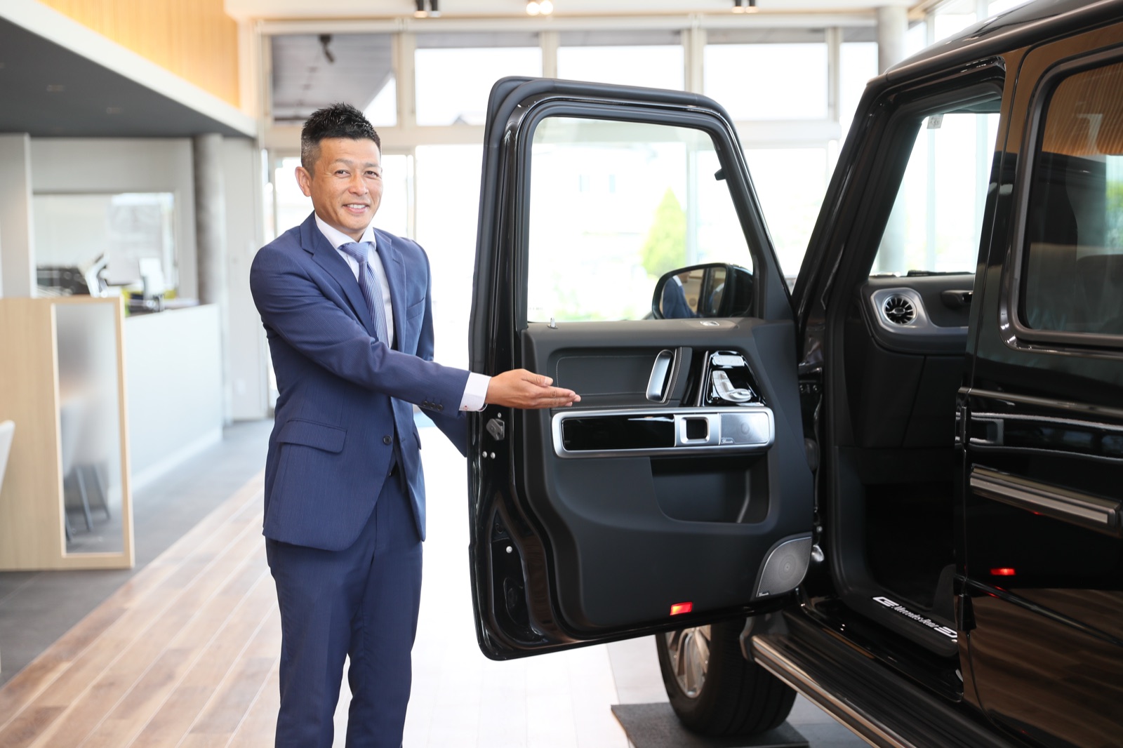 岡山のバンガード本店で、車のドアを開けて案内するスタッフ