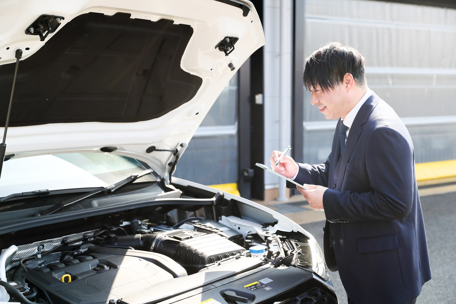 エンジンルームを確認し、車両の状態を記録するバンガードのスタッフ